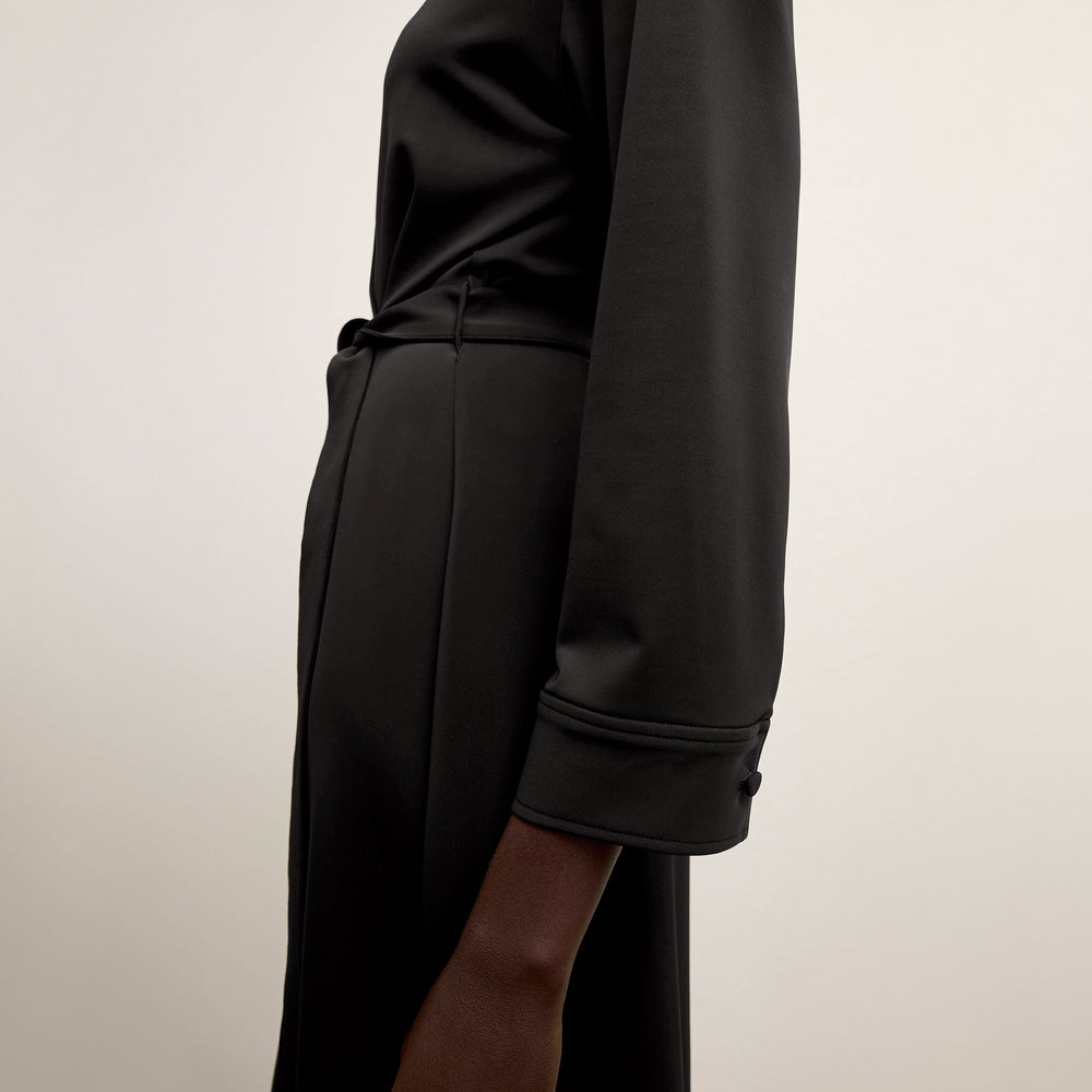 side image of a woman wearing the emmett dress in black