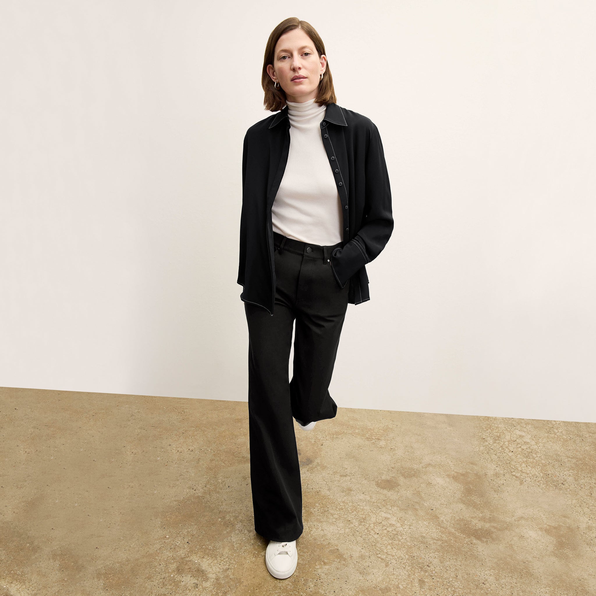 Front image of a woman standing wearing the axam top in ivory