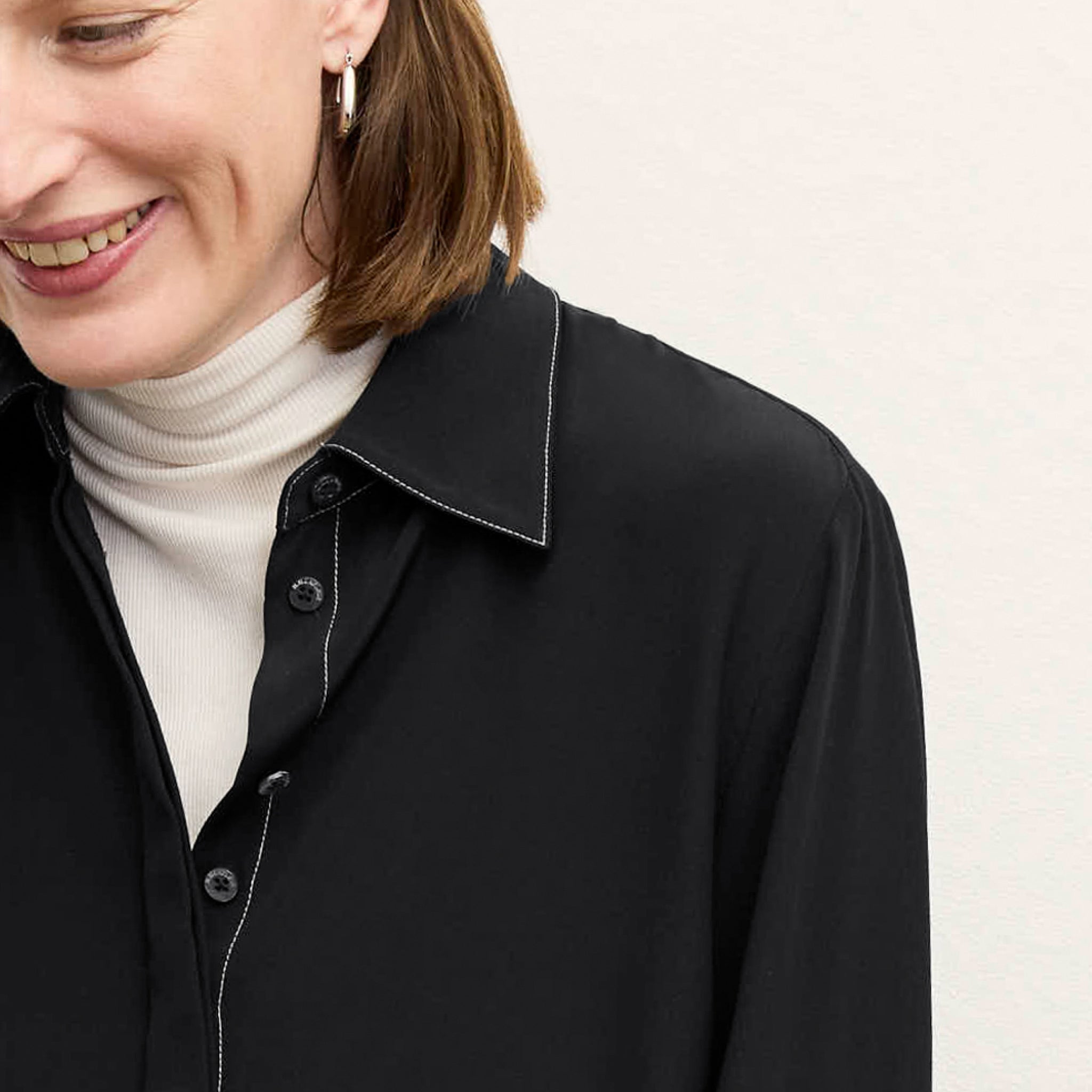 front image of a woman wearing the mira top in black