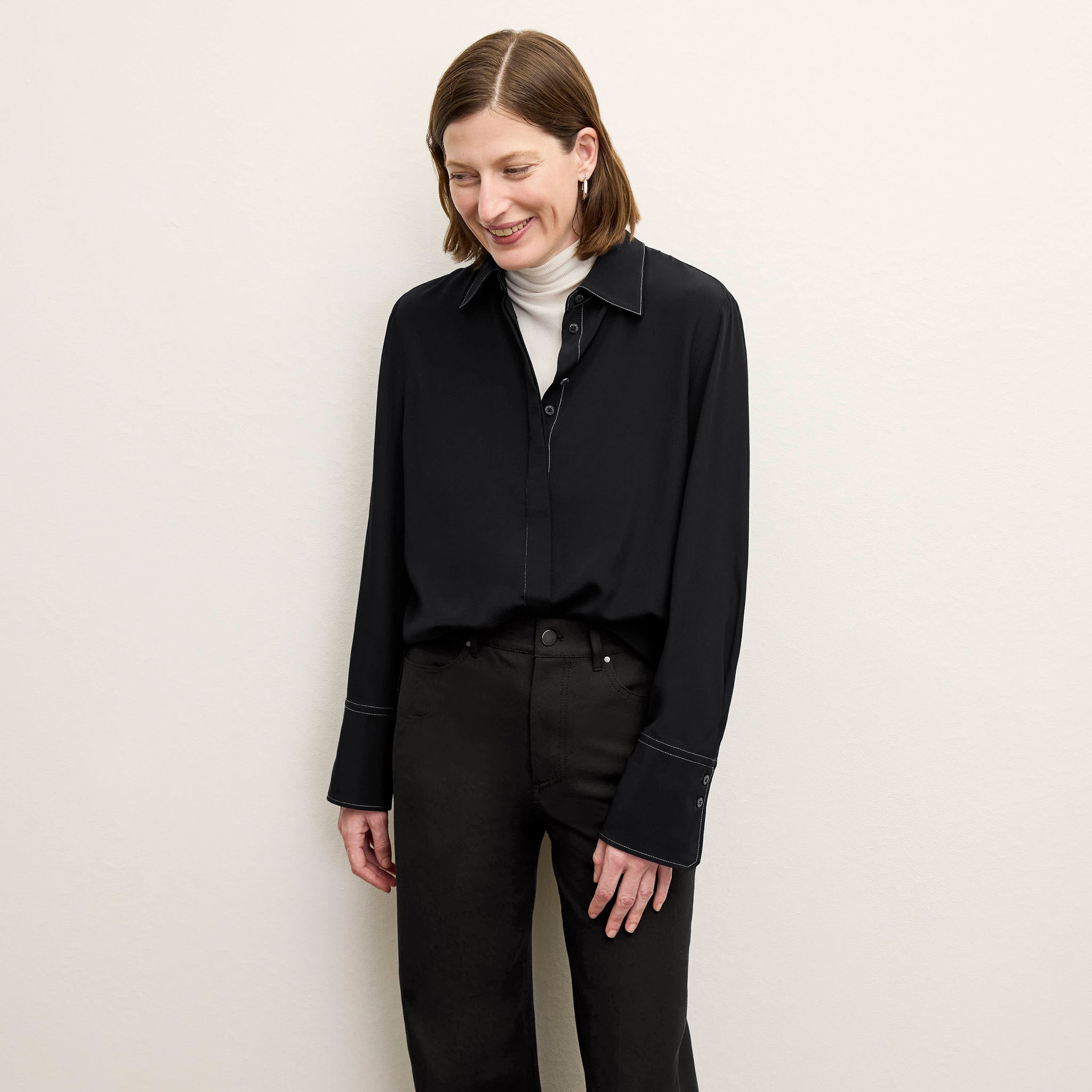 Front image of a woman standing wearing the axam top in ivory