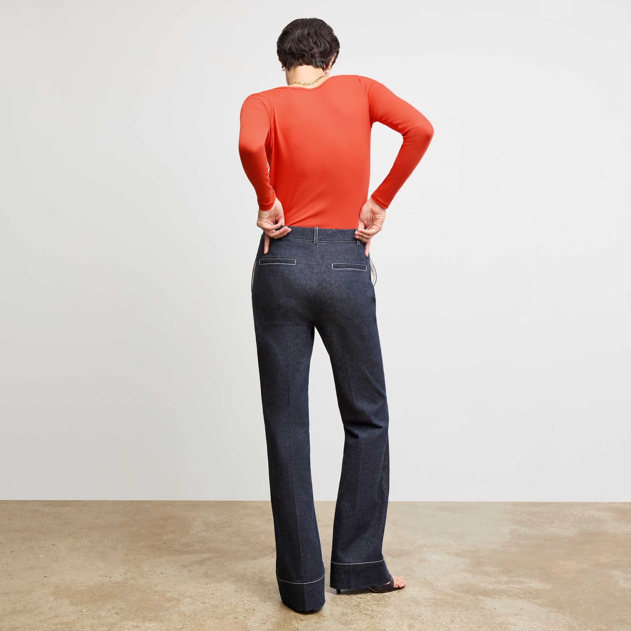 back image of a woman wearing the rowe pant in midnight wash