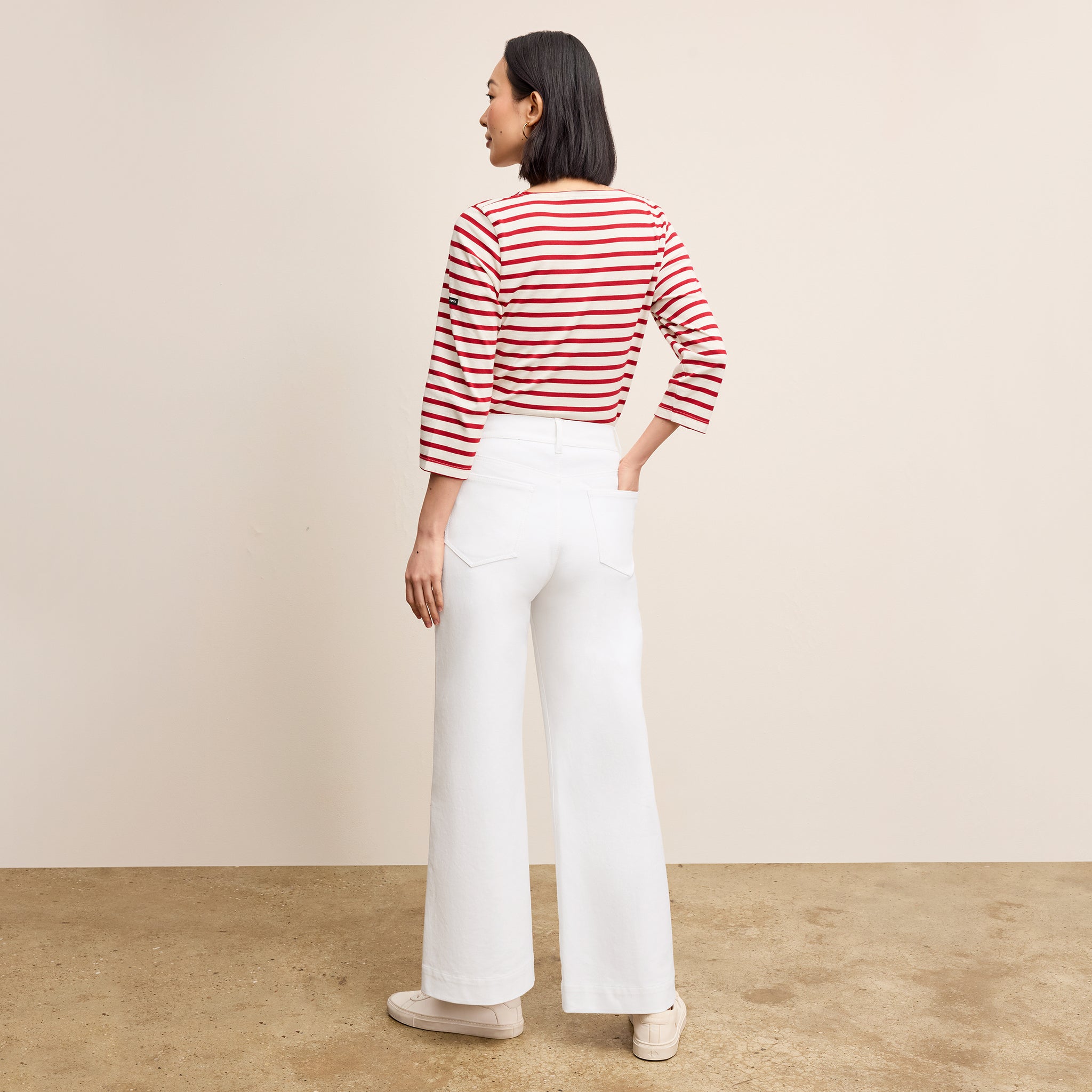 back image of a woman wearing the milo jeans in white