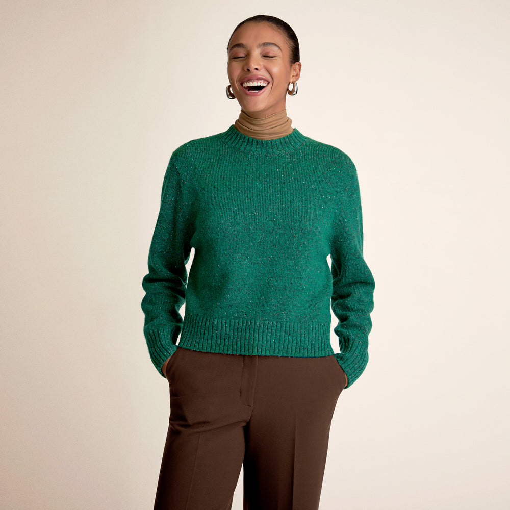 Woman wearing a green sweater with brown pants