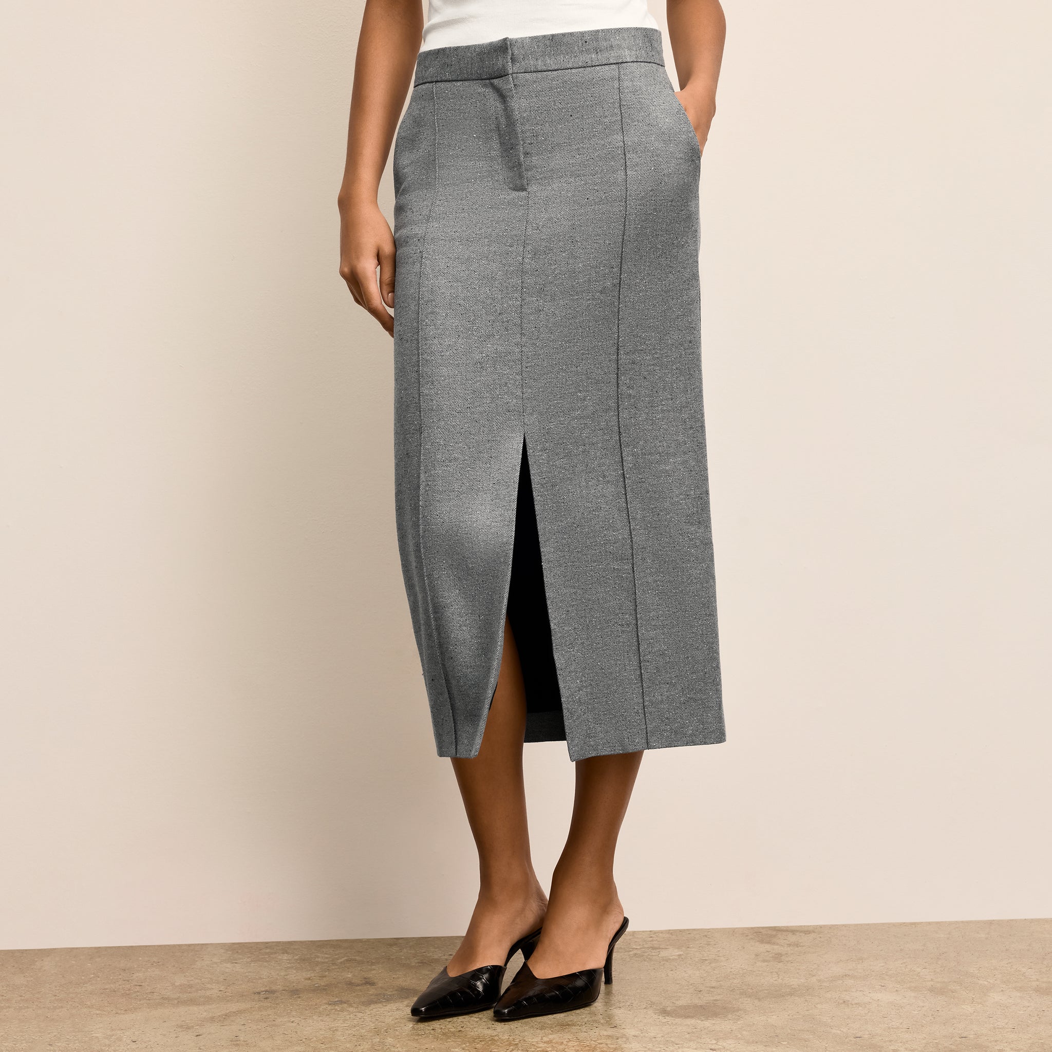 Gray skirt worn by a person on a beige background