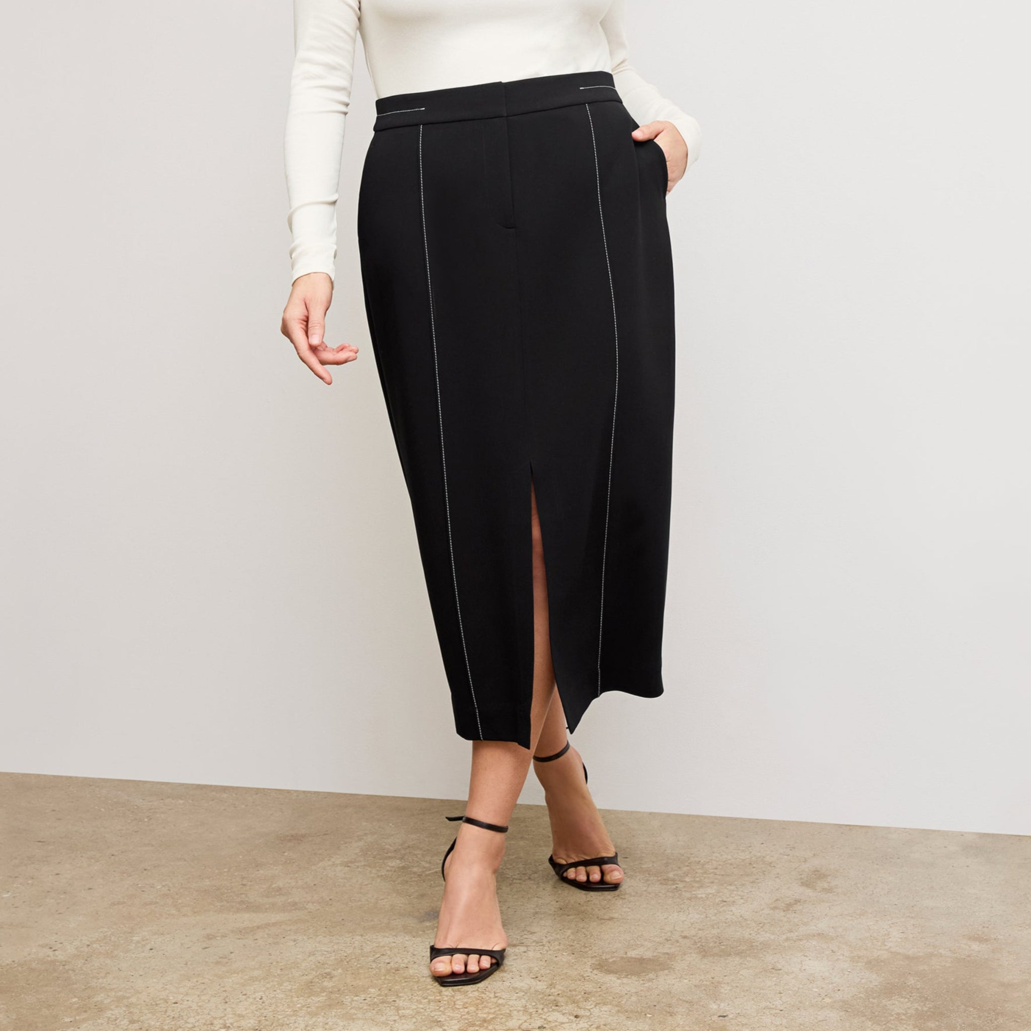 front image of a woman wearing the meghan skirt in black with topstitch 