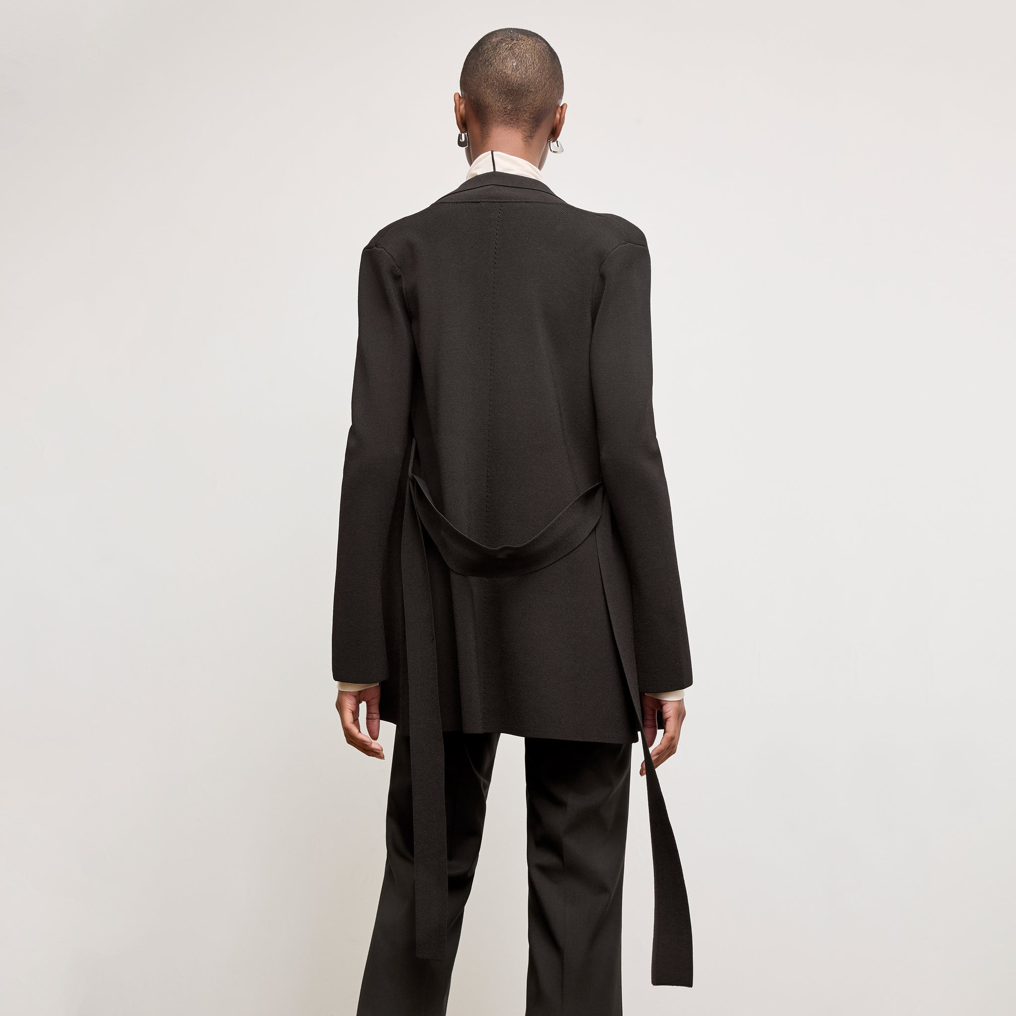 Black image of a woman standing wearing the Merritt jardigan in Black