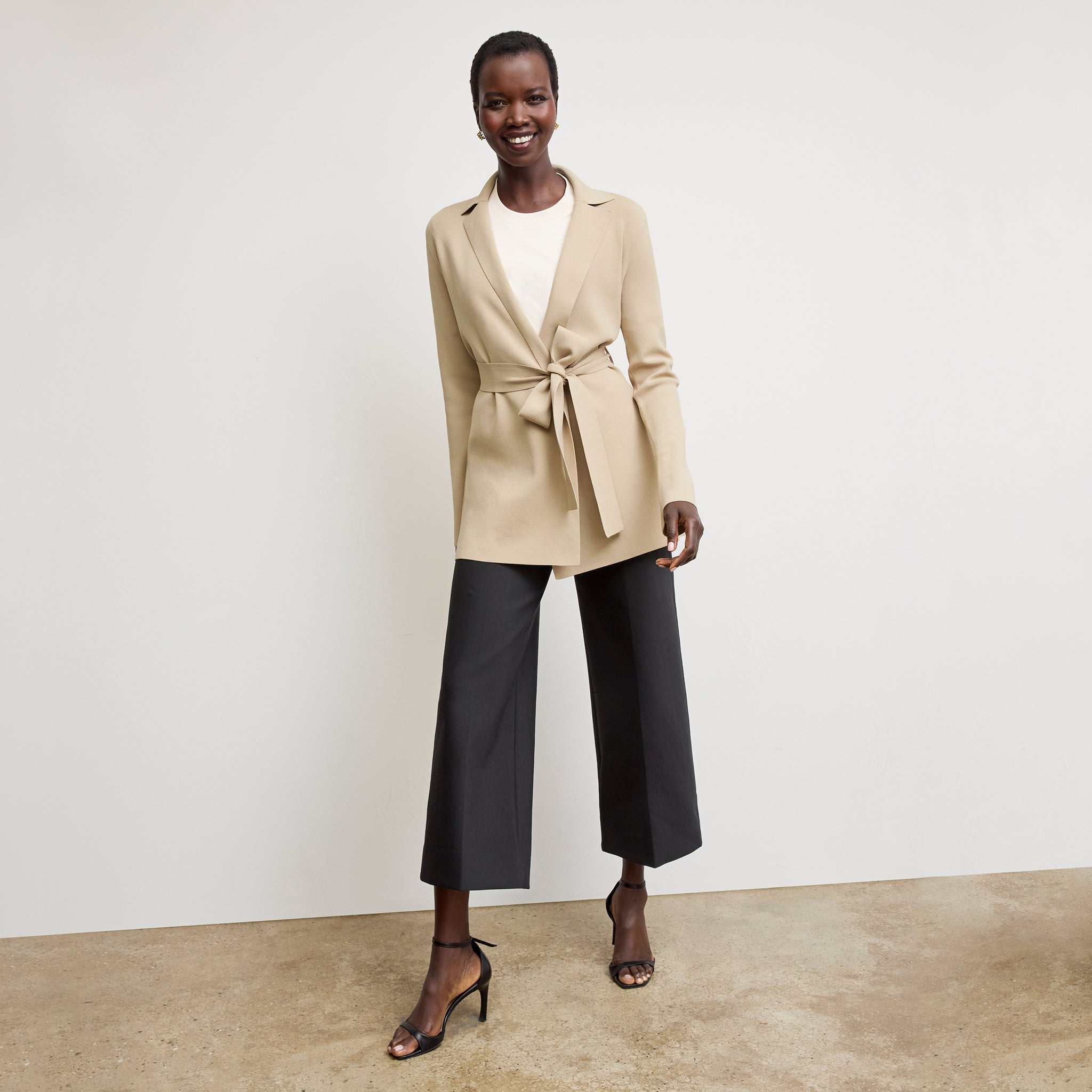 Front image of a woman standing wearing the Merritt jardigan in latte