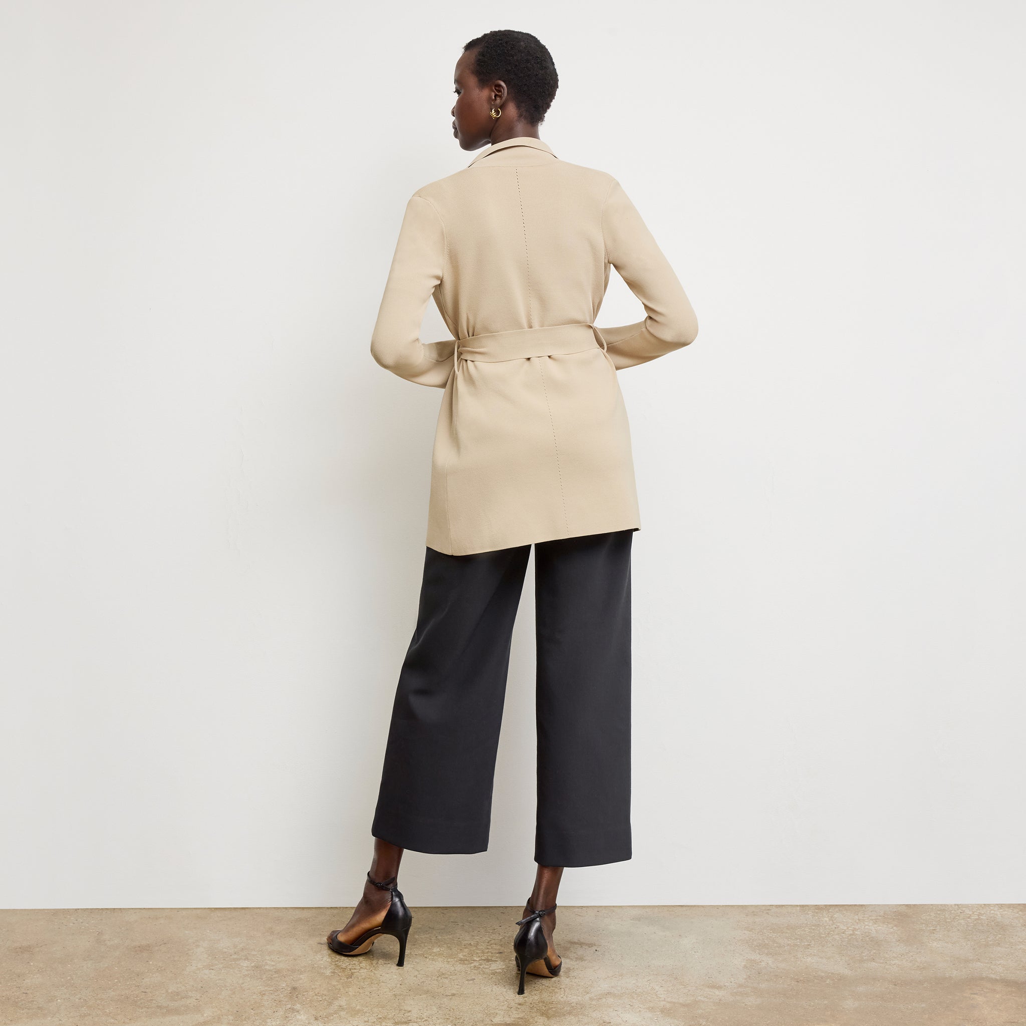 Back image of a woman standing wearing the Merritt jardigan in latte