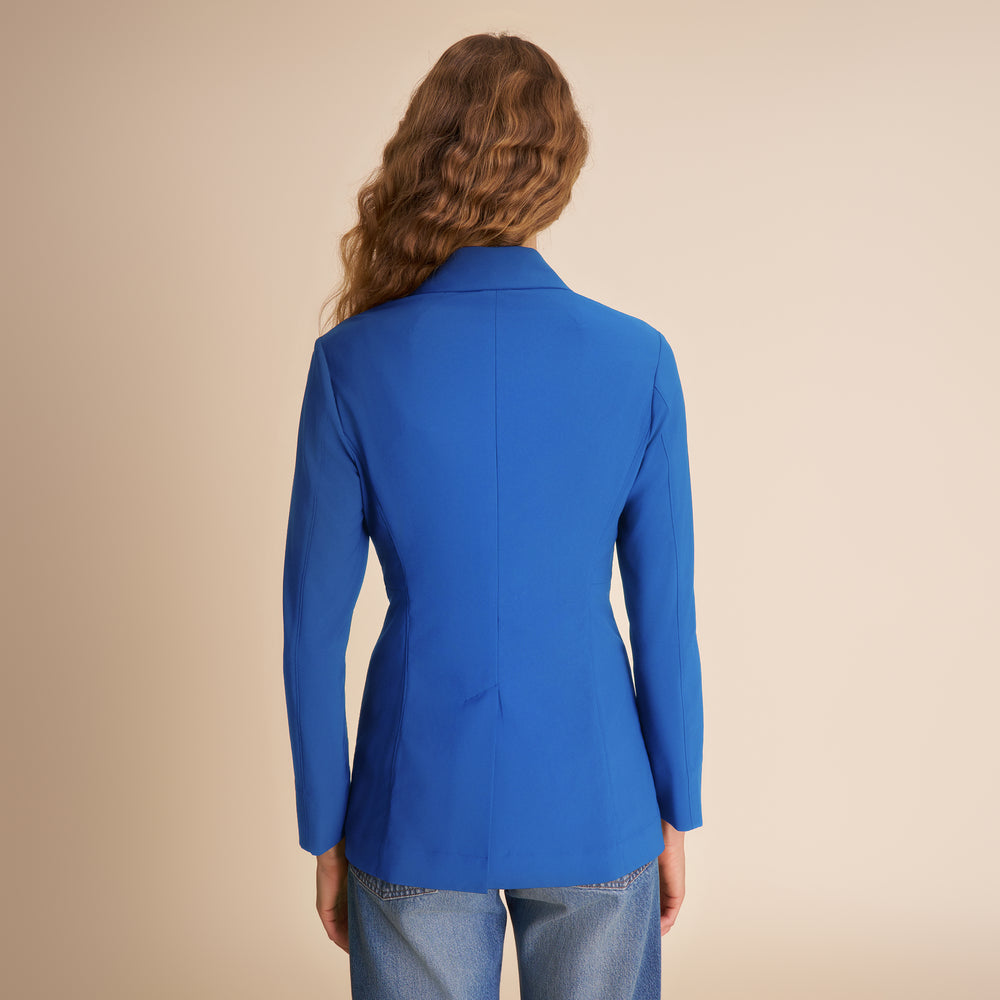 Person wearing a blue blazer on a beige background