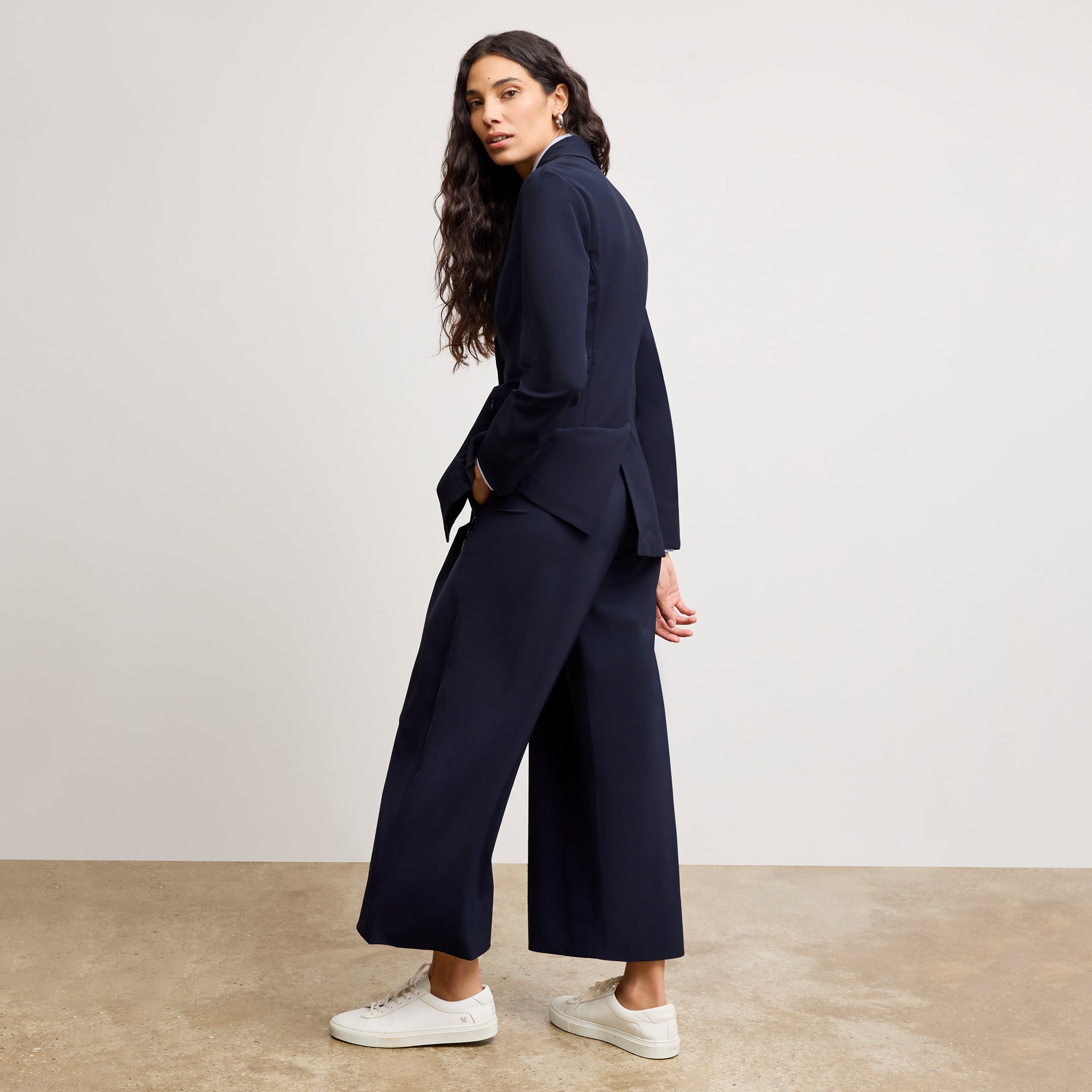 back image of a woman wearing the moreland jacket in dark navy