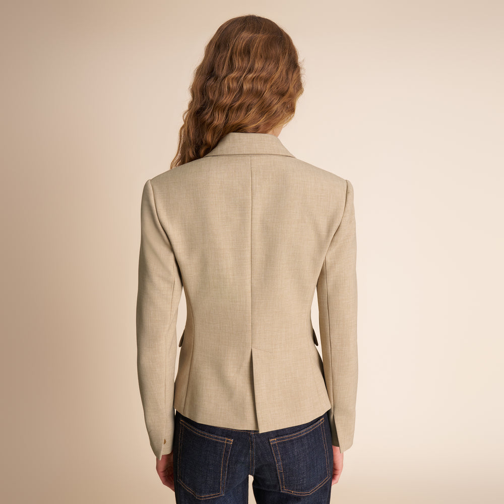 Beige blazer worn by a person on a beige background