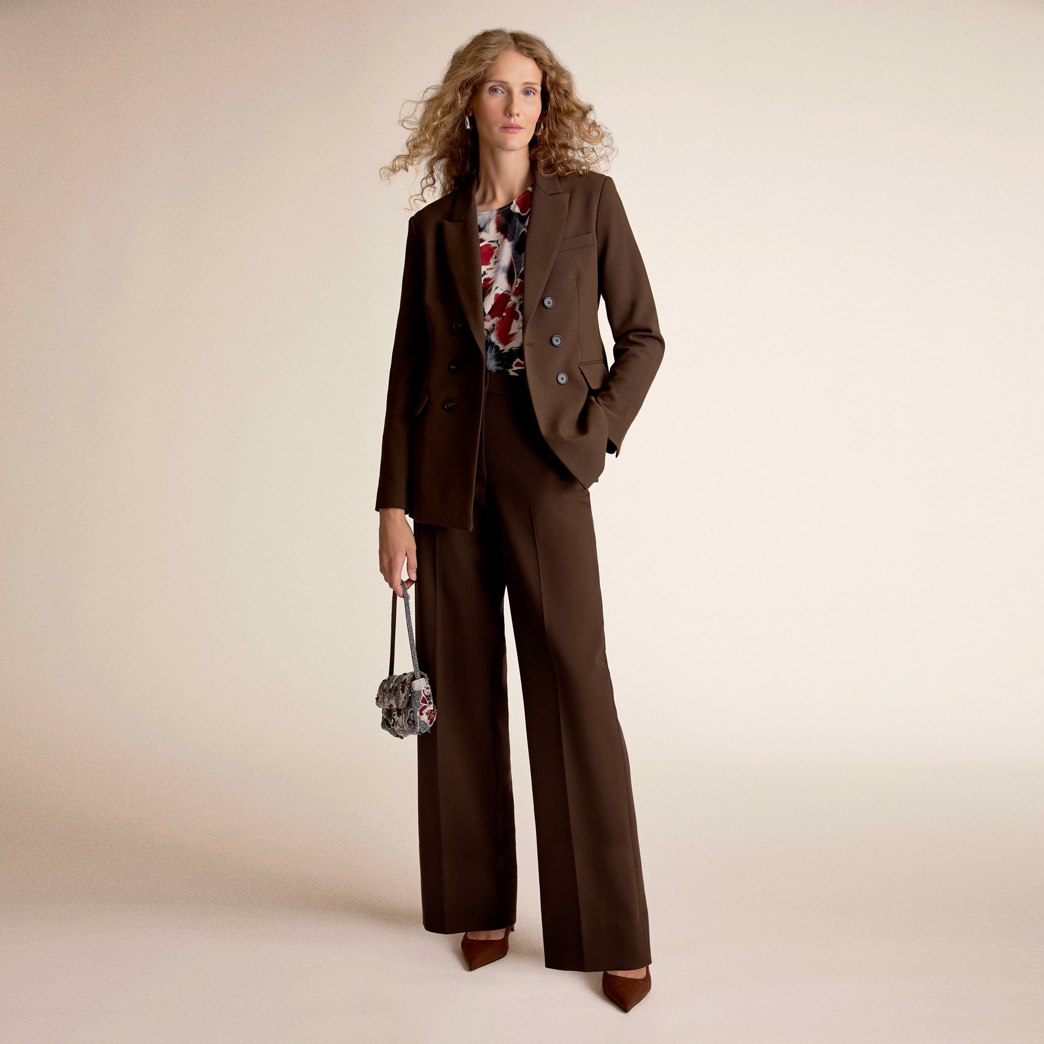 A woman wearing brown pants and brown blazer