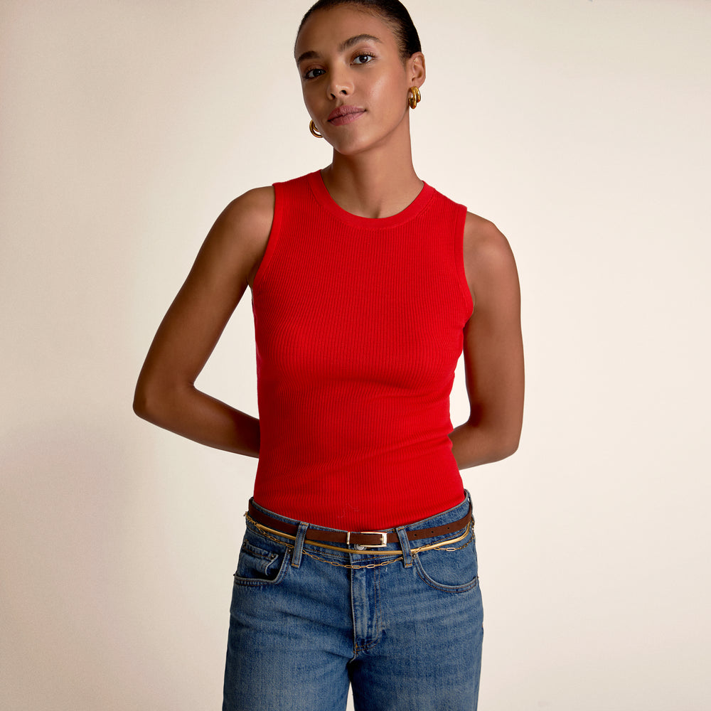 A woman wearing a red top and blue jeans