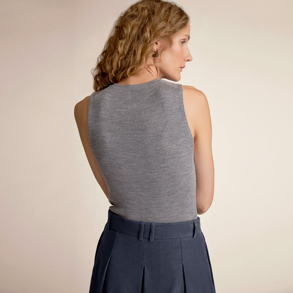 Woman wearing a gray tank top and a blue skirt