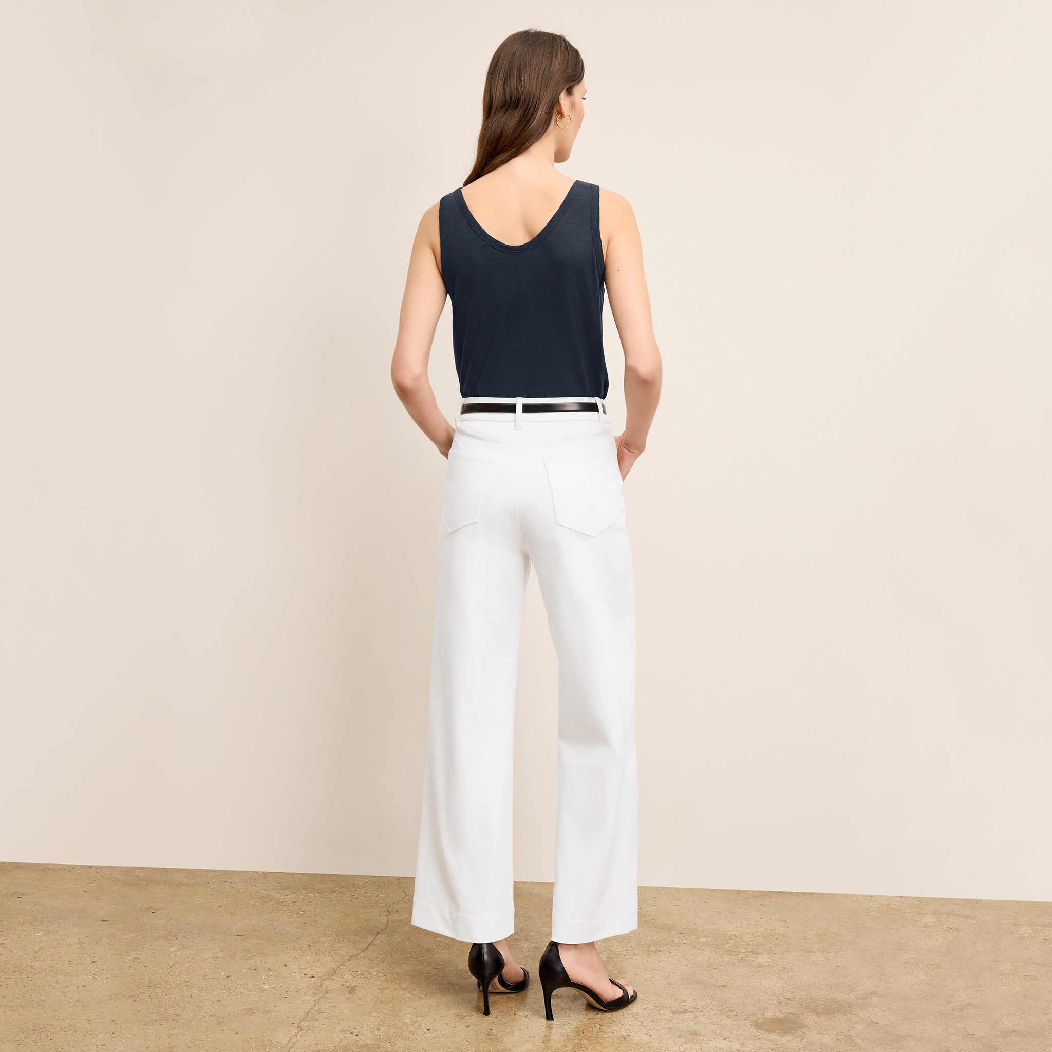 back image of a woman wearing the milo jeans in white
