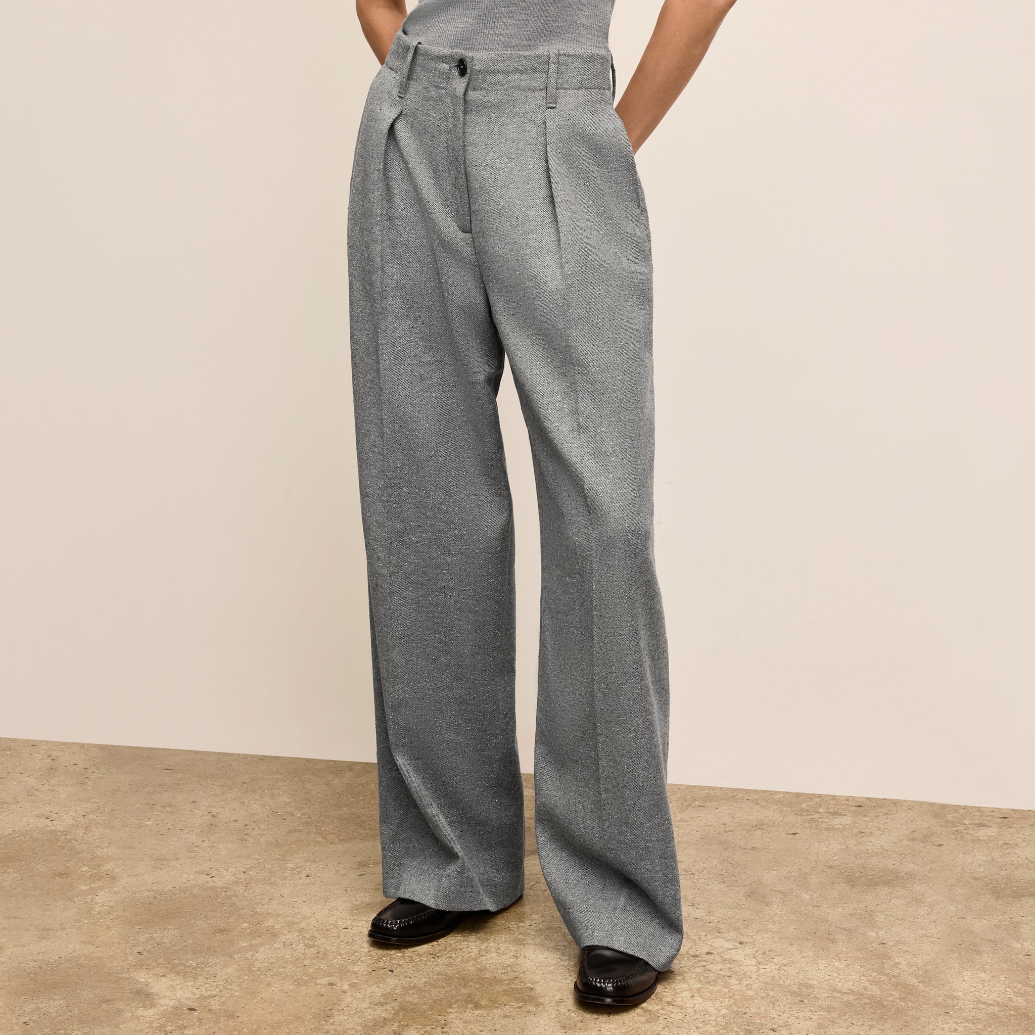 Person wearing gray wide-leg pants on a beige background 
