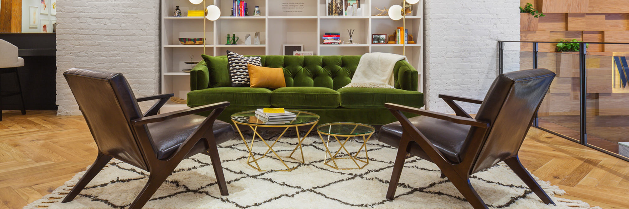 Modern living room with green sofa, brown chairs, and a coffee table.