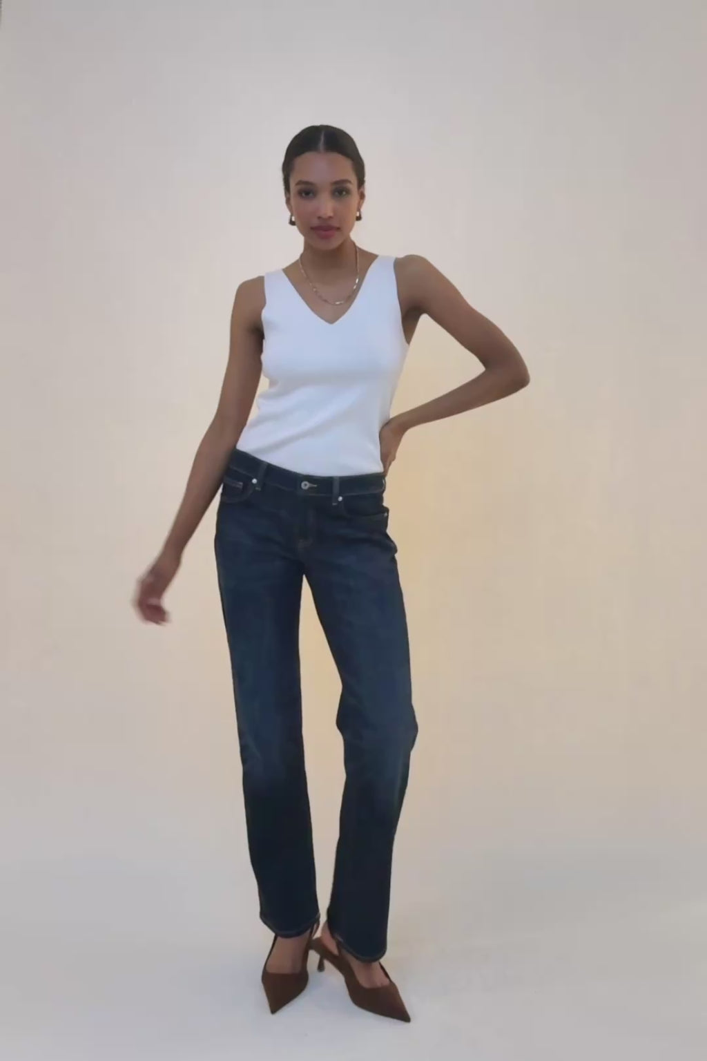woman in white tank and blue jeans.