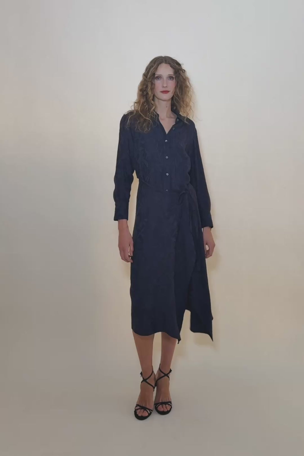 Video of a woman wearing a navy floral jacquard dress showing the movement of the full skirt and tie waist