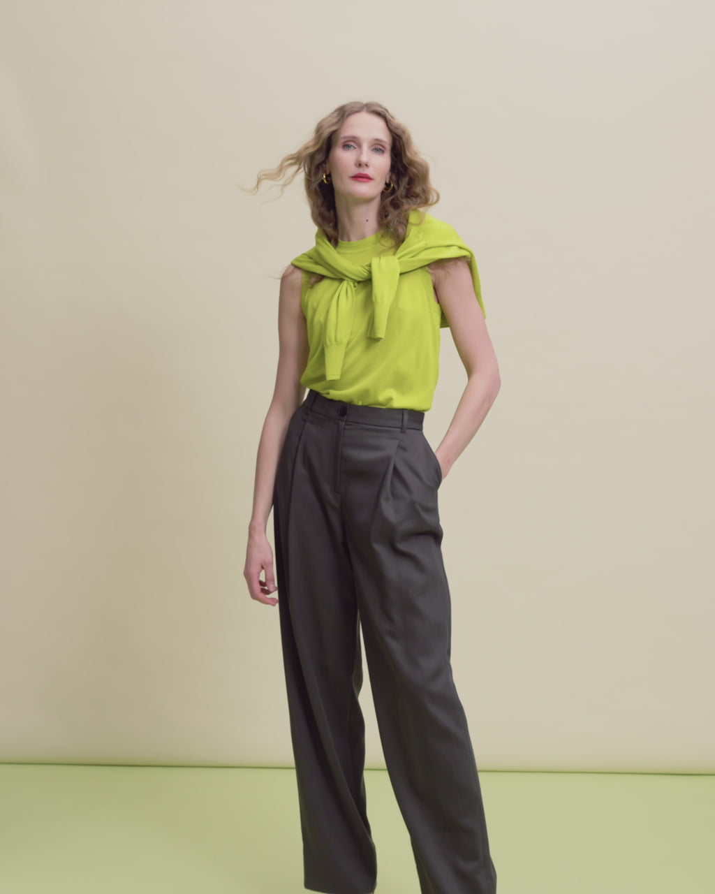 woman in pineapple top with dark trousers.