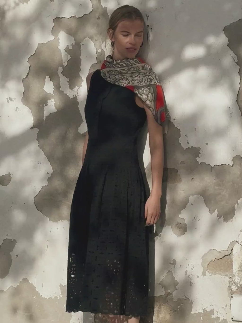 woman in black dress with red scarf.