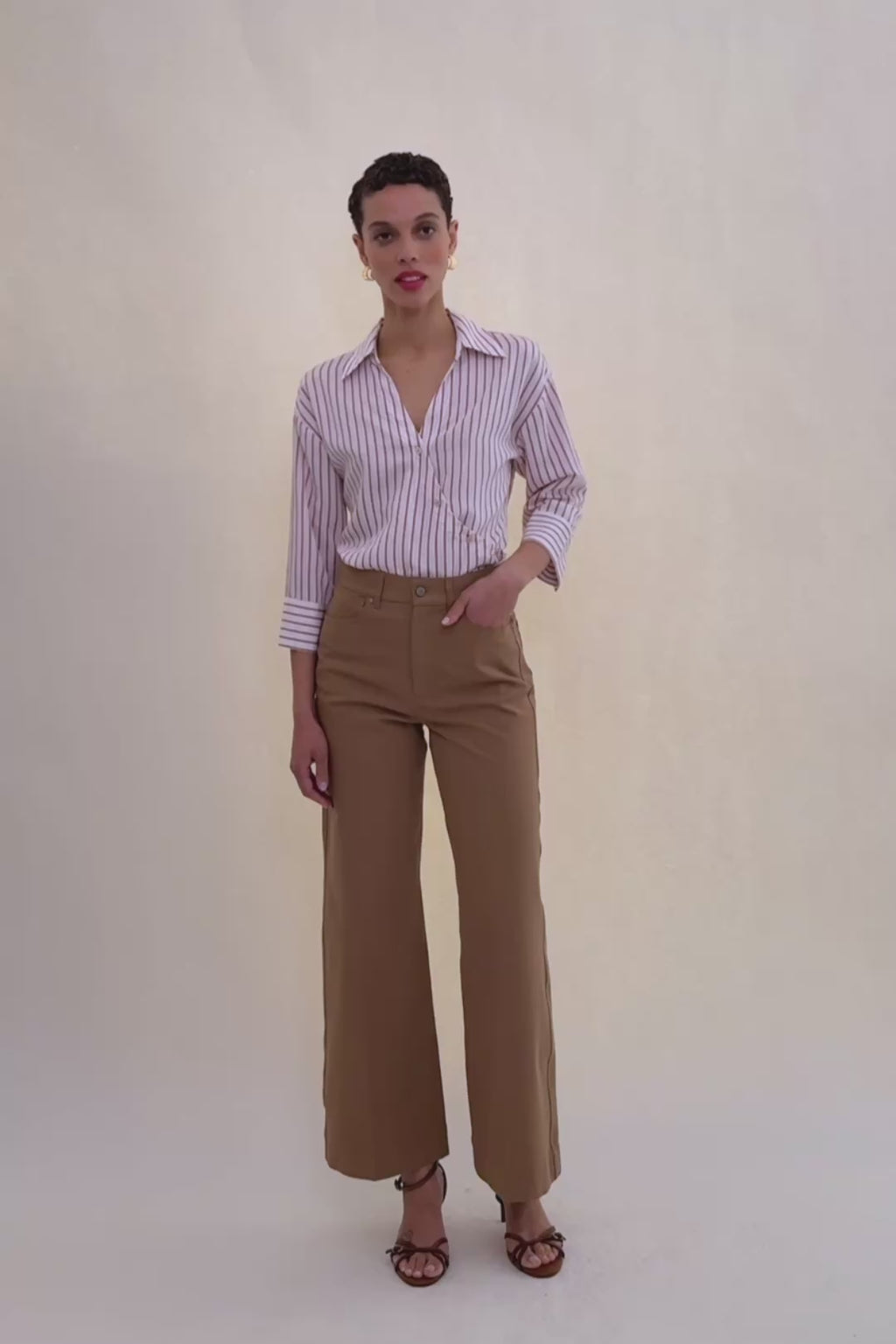 woman in stripped shirt and beige jeans.