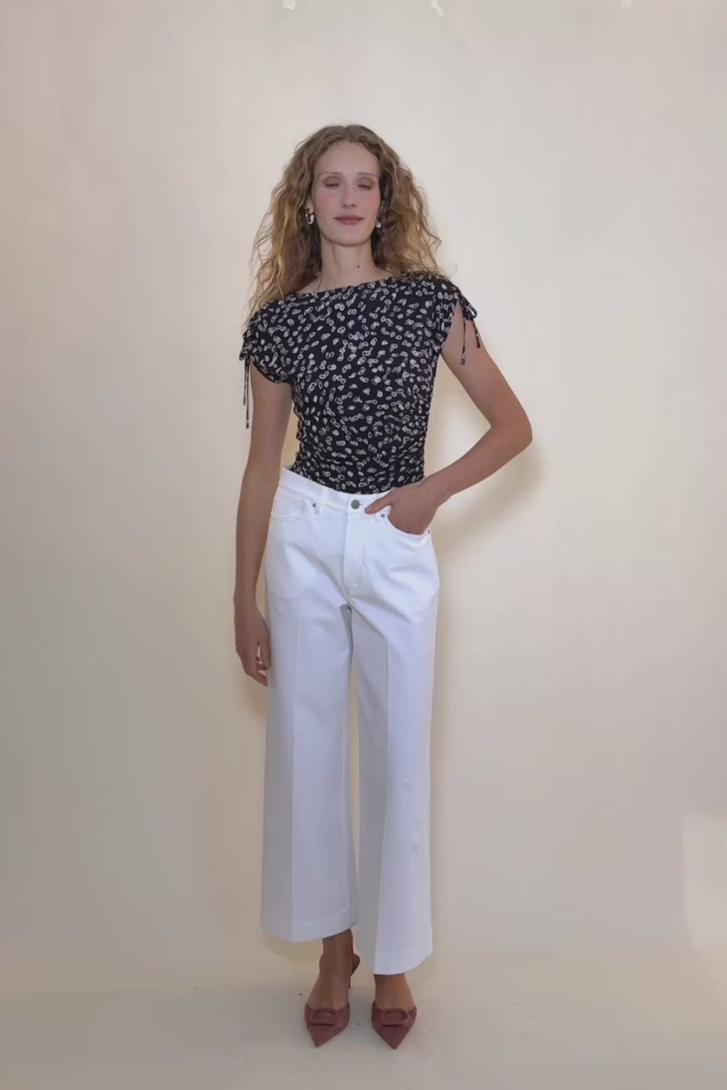 woman in spin dot top with white pants. 