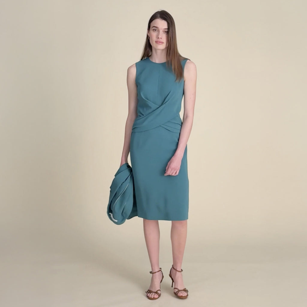 Woman wearing a teal dress on a beige background