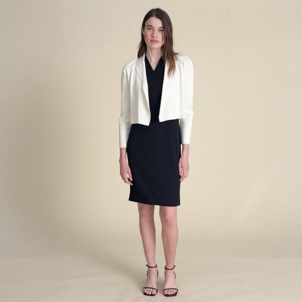 woman in black dress with white cardigan.