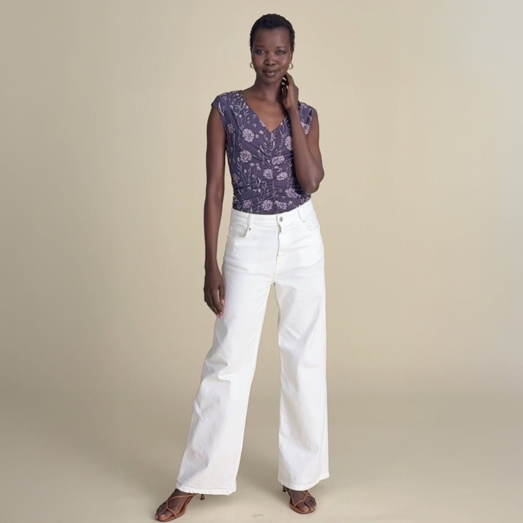 woman in purple top with white jeans