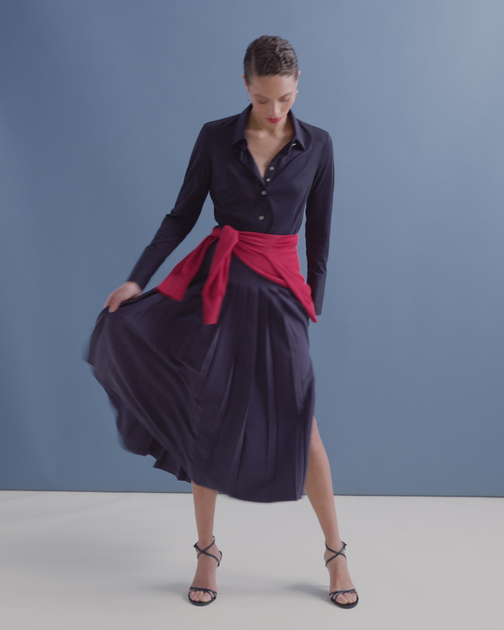 Woman wearing a navy dress on a blue background