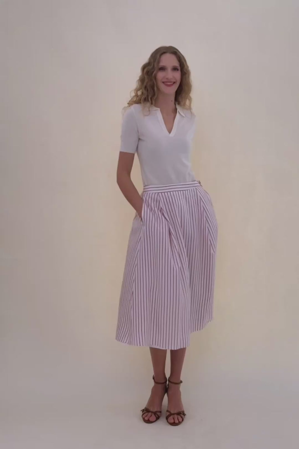 woman in stripped skirt and white polo.