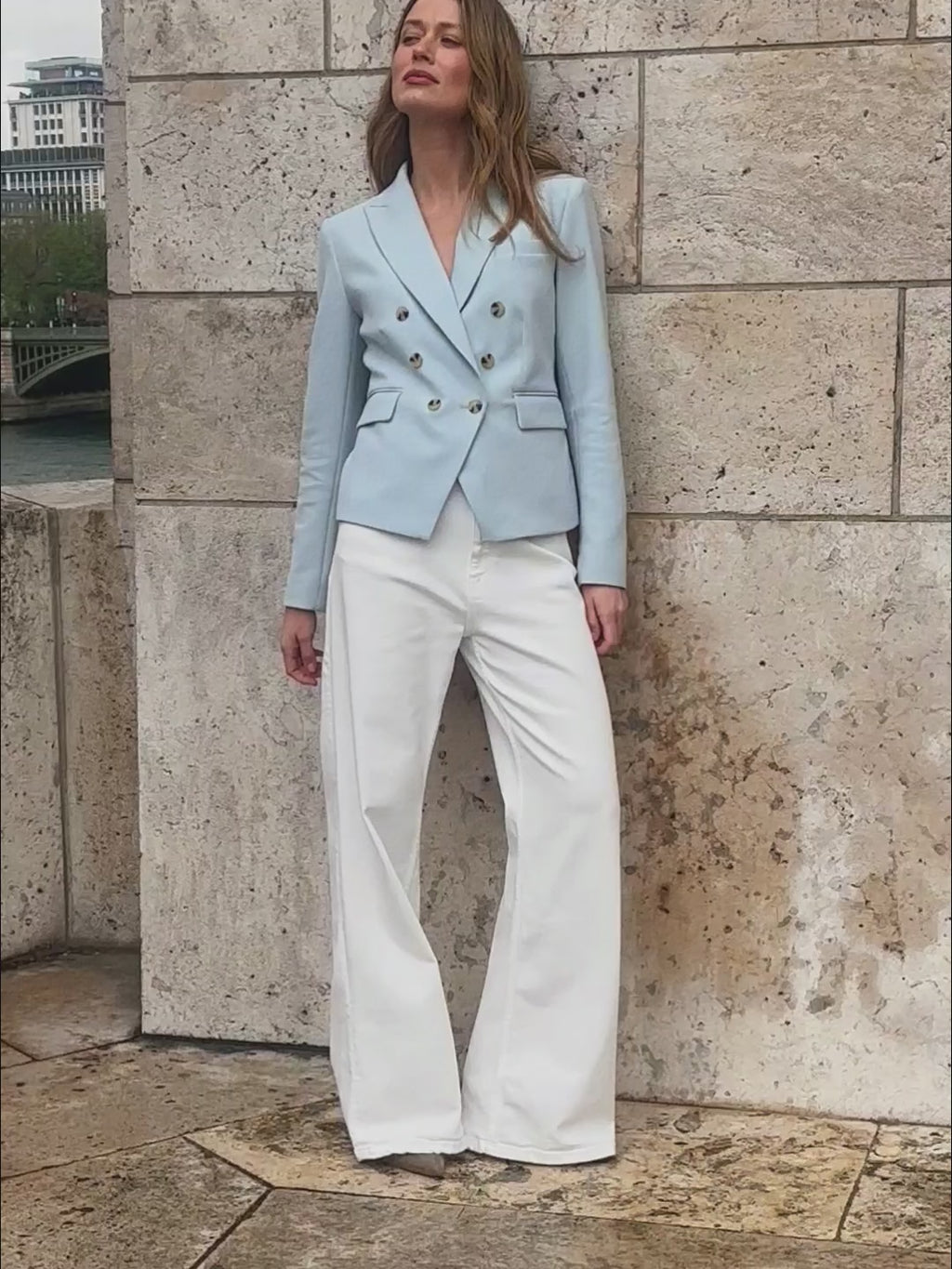 woman in light blue blazer with white pants. 