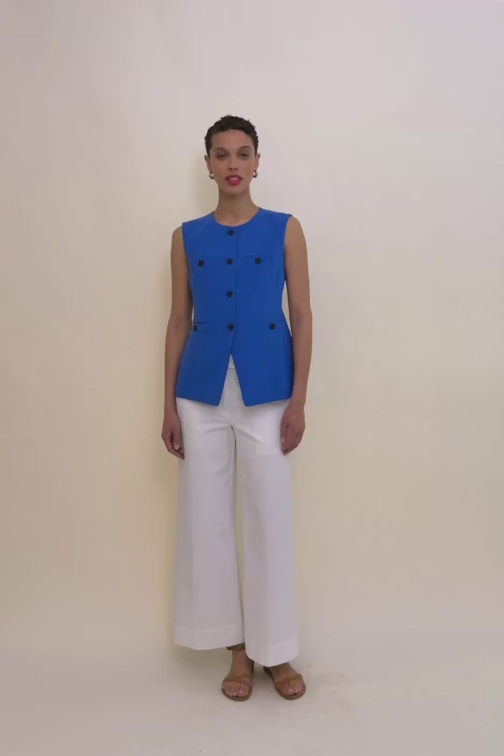 woman in ocean blue vest and white jeans. 