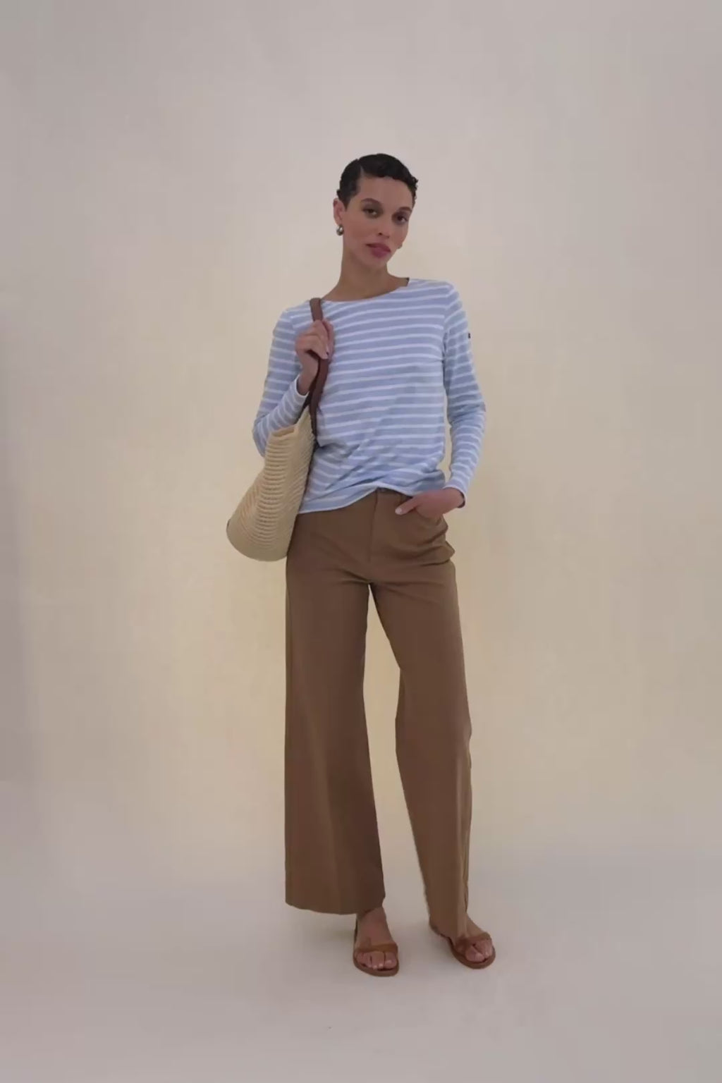 woman in blue and white stripped shirt with beige pants.