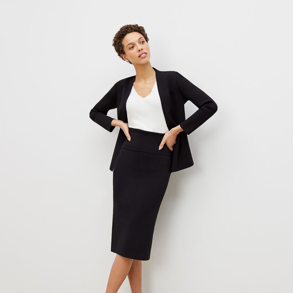 Front image of a woman standing wearing the harlem skirt in black