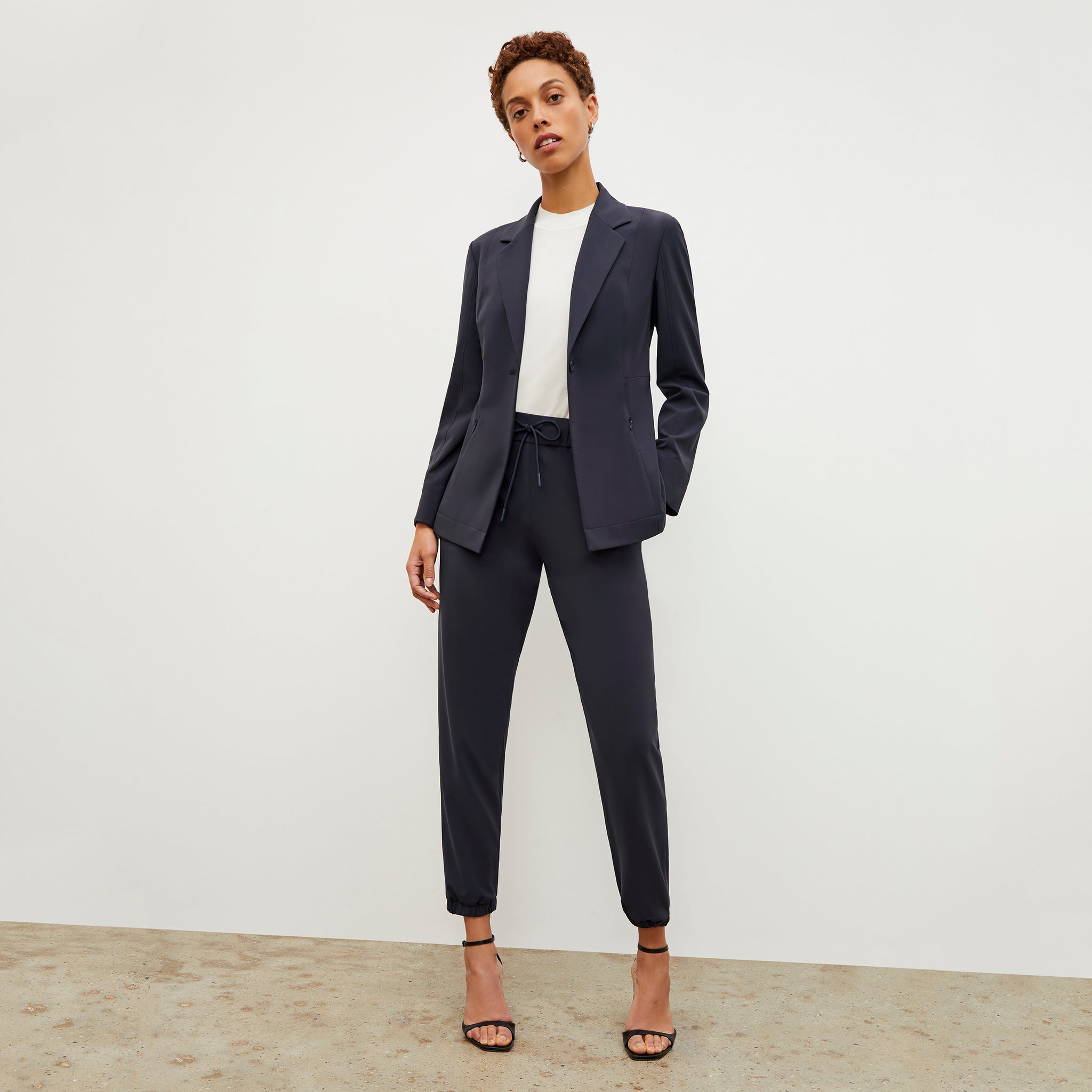 Front image of a woman standing wearing the Moreland Jacket—Origami Suiting in Cool Charcoal