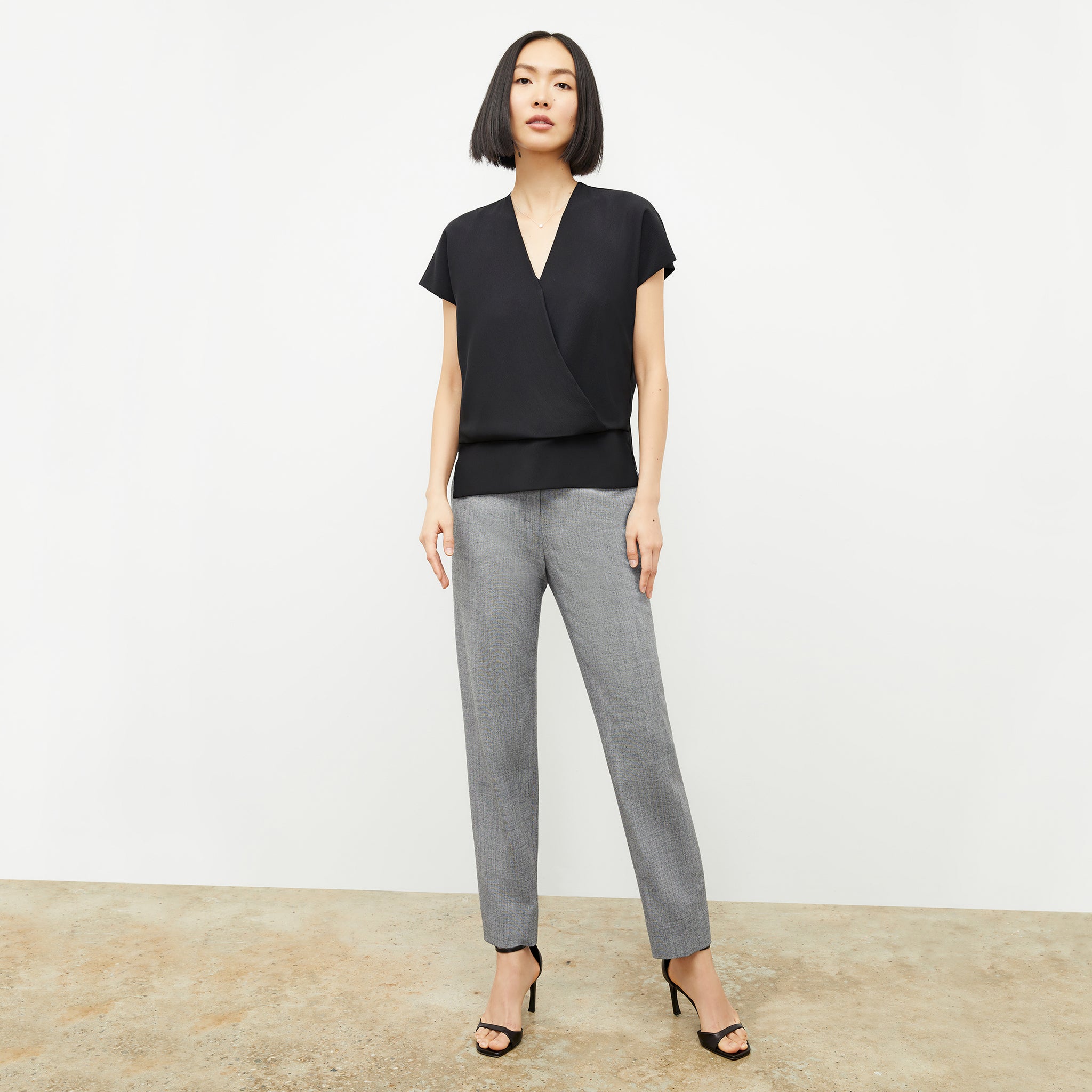 Front image of a woman standing wearing the antonia top soft wave in black