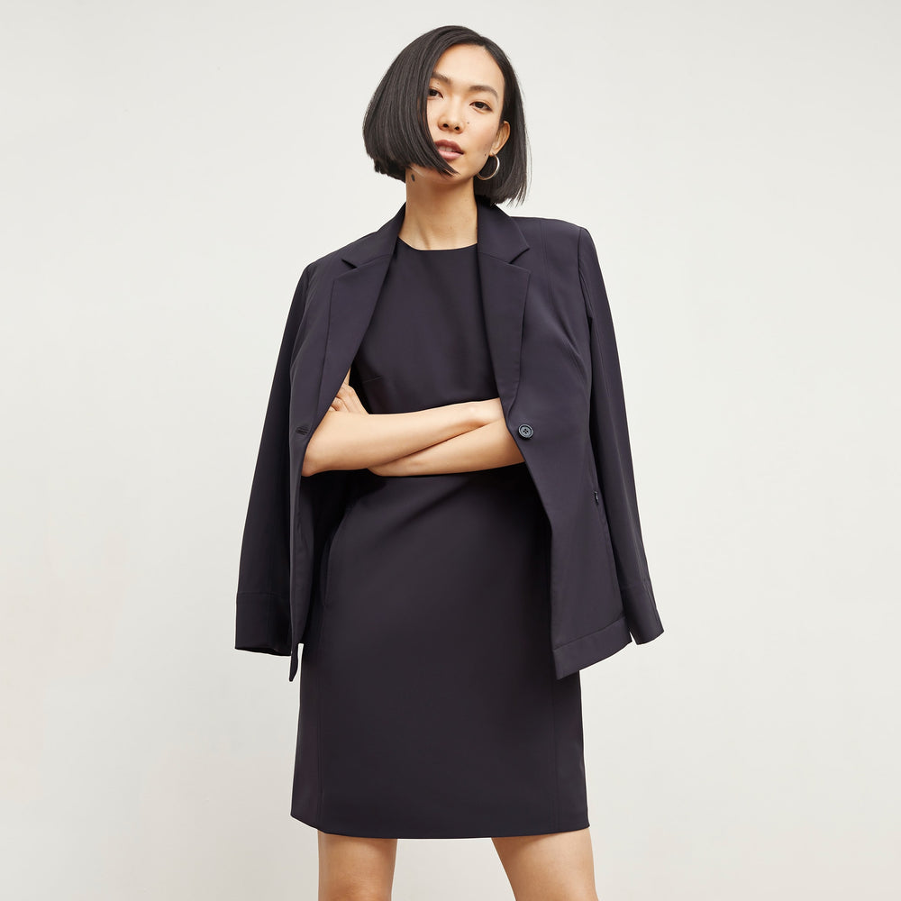 Front image of a woman standing wearing the Maaza Dress—Origami Suiting in Cool Charcoal