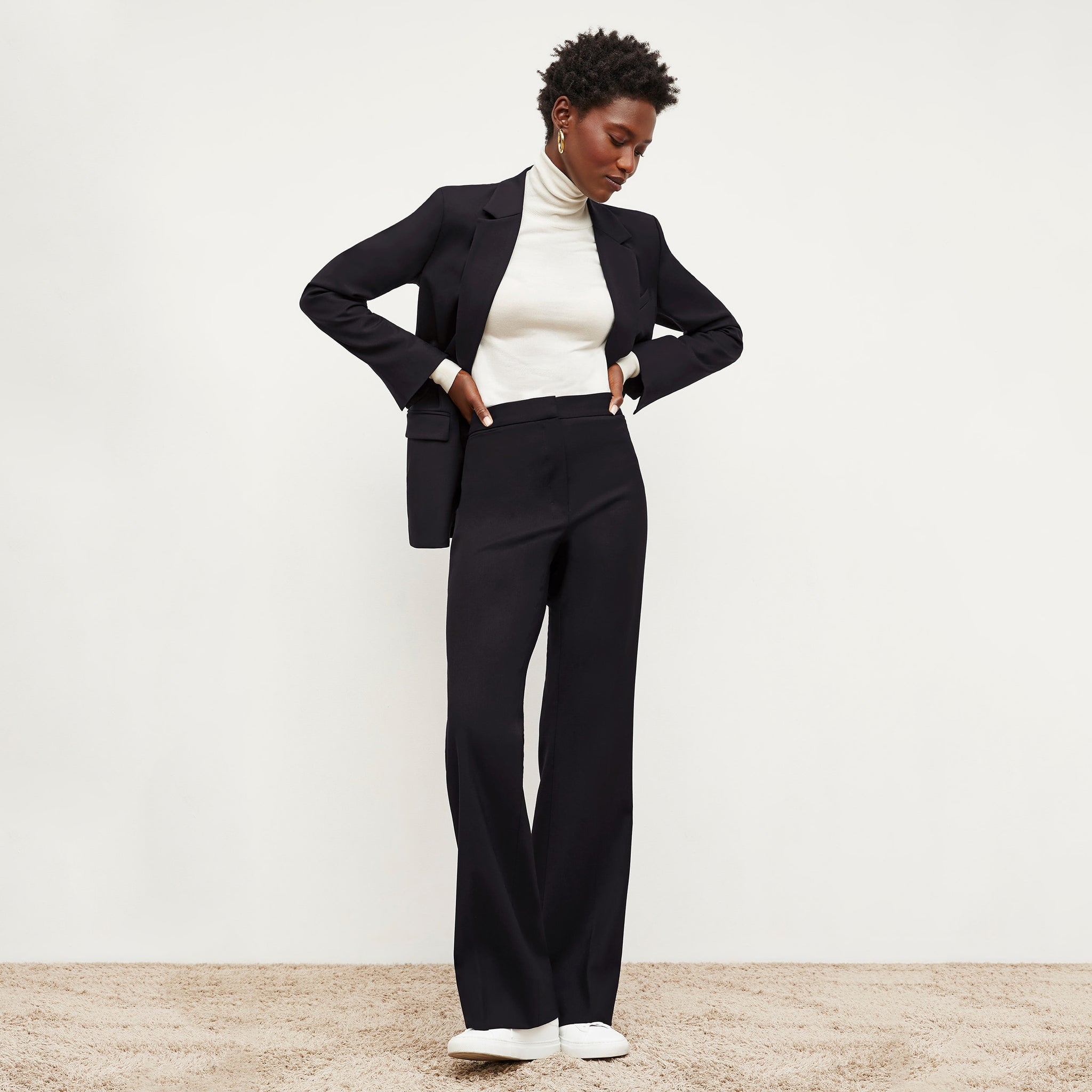 Front image of a woman standing wearing the Yiyan Blazer in Black